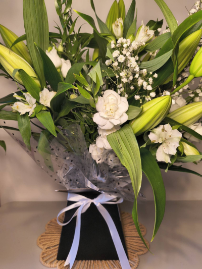 White Petal Harmony - A blend of all‑white blooms in a calm, balanced arrangement. With soft textures and a clean, unified palette, this bouquet adds a fresh, serene presence to any space — simple, polished, and effortlessly elegant.