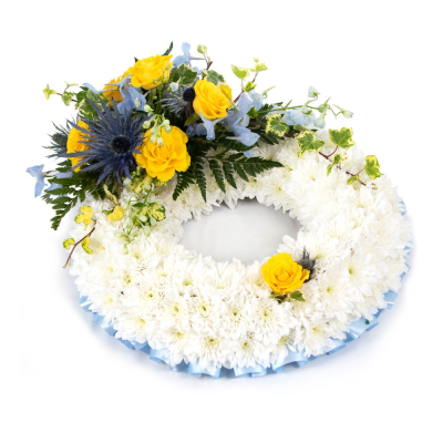 Blue & Yellow Wreath Based with Spray - A traditional wreath of massed white Chrysanthemums with a corsage of flowers in Blue and Yellow blooms. Edges with ribbon. 

Please note images are examples only, flowers used may